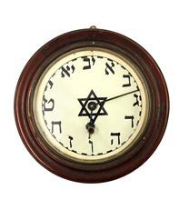 תמונה של שעון קיר מכני עם אותיות עבריות. המאה ה-20.